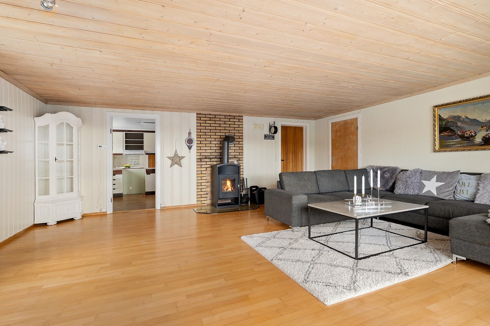 Fra kjøkkenet kommer du inn i stuen hvor du har vedovn og varmepumpe Galleribilde