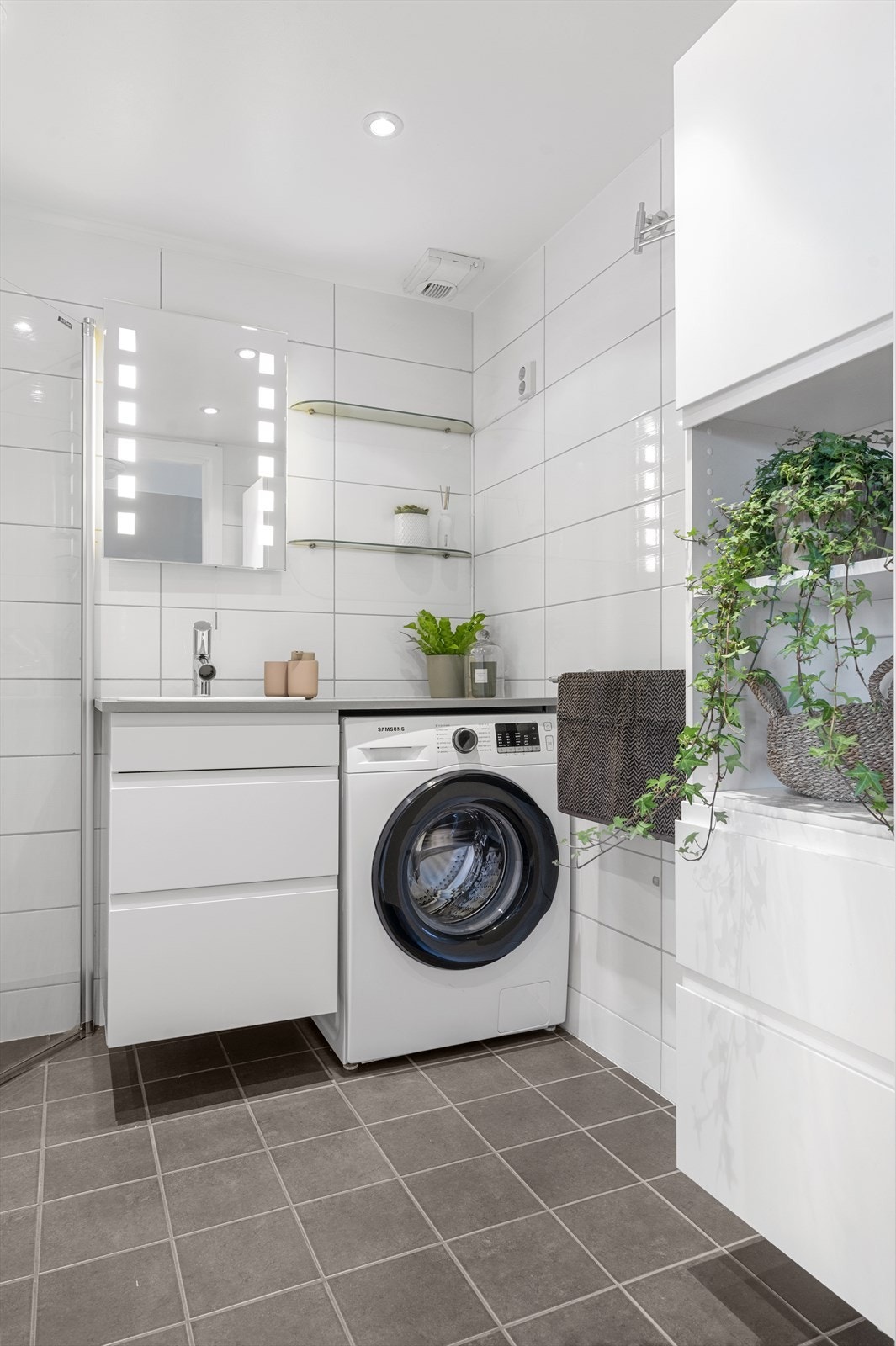 Innredningen består av servant med skuffeinnredning, vegghengt toalett med innebygget sisterne og dusj på gulv med dusjdører i herdet glass. Badet har opplegg for vaskemaskin og avtrekk tilkoplet felles ventilasjonsanlegg. Galleribilde