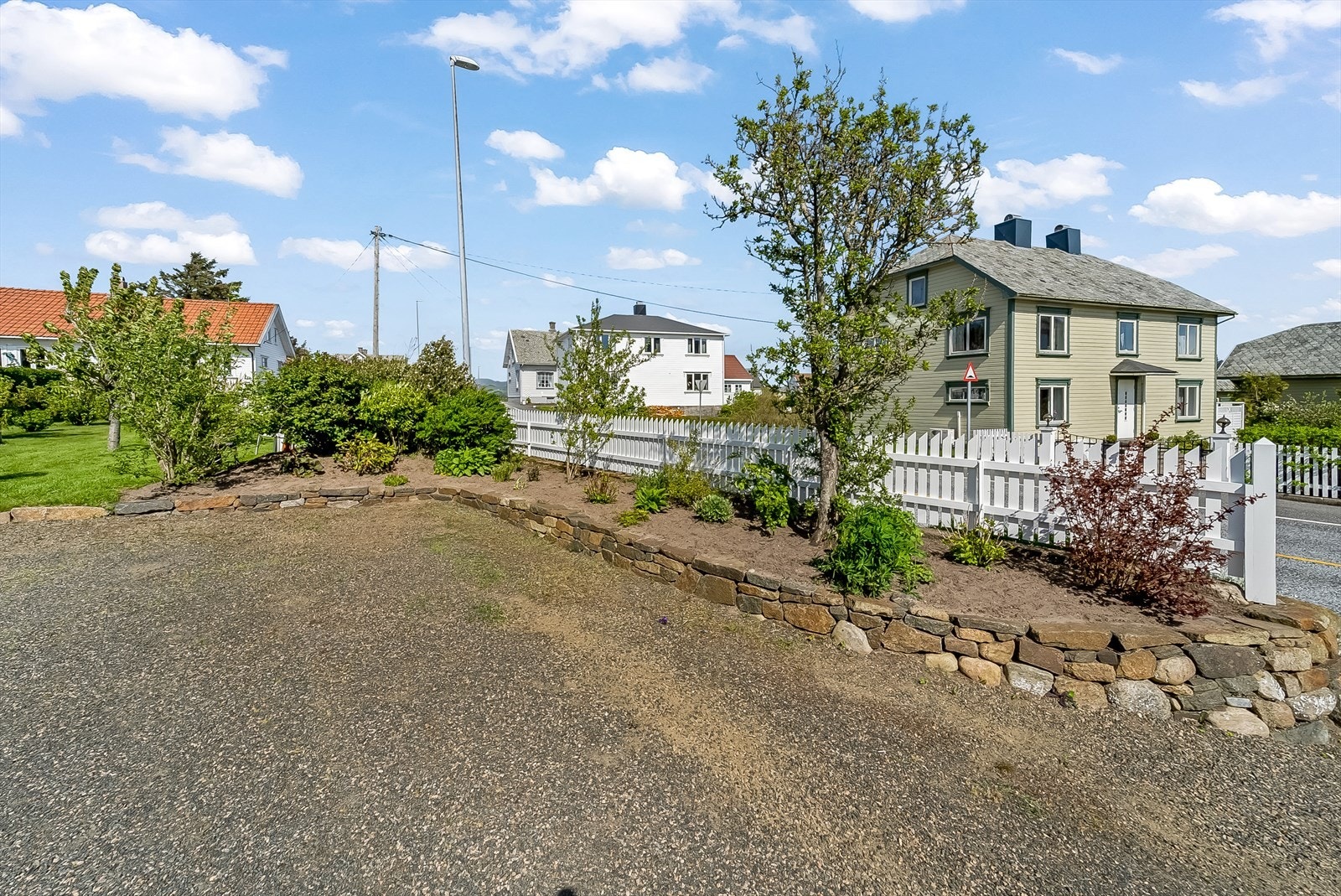 Gruslagt parkeringsområde med fin beplantning. Galleribilde