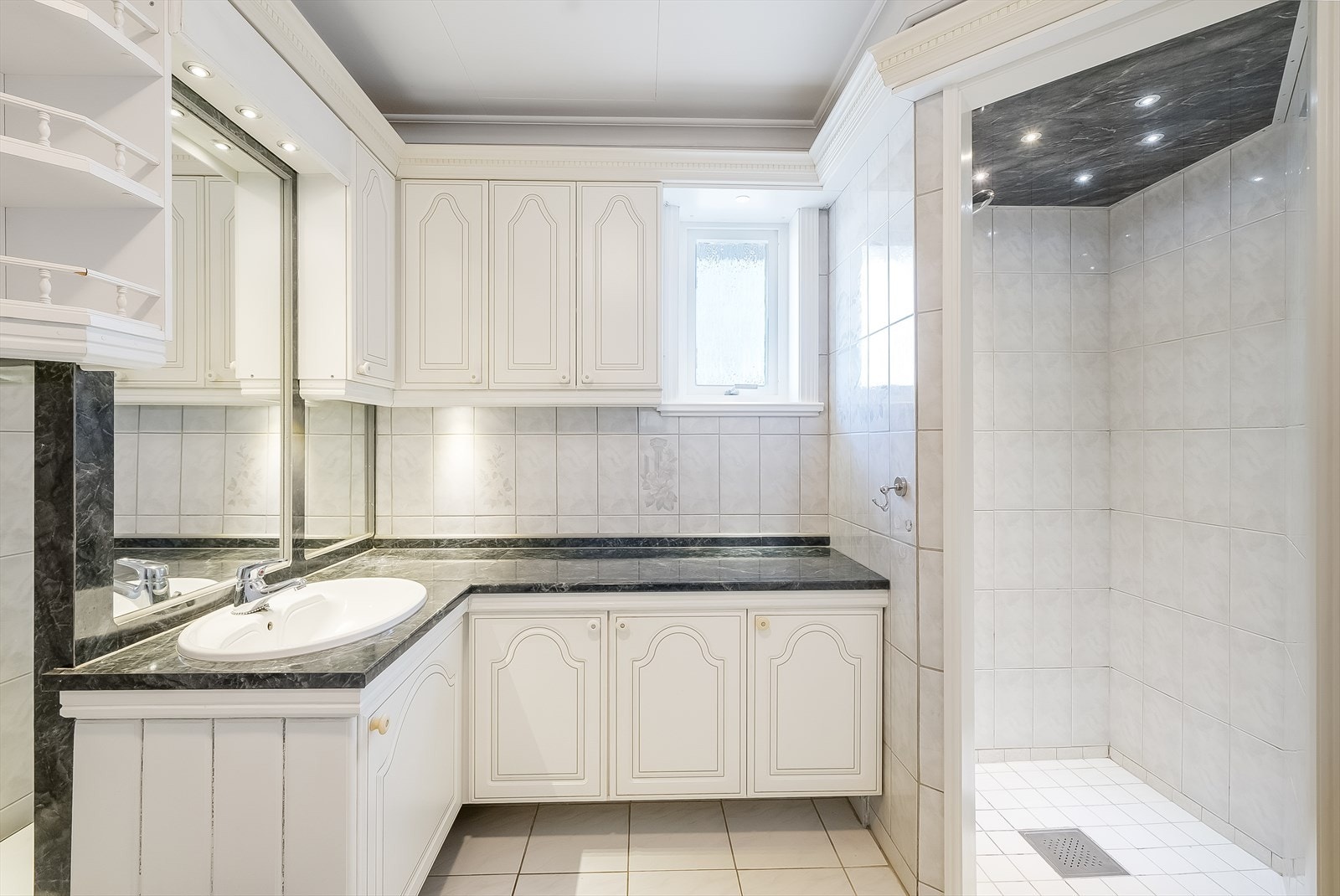 Bad i 1. etasje. Badet er pent innredet med fliser på gulv og vegger. Badet er innredet med baderomsinnredning, nedsenket badekar, dusjnisje og toalett. Galleribilde