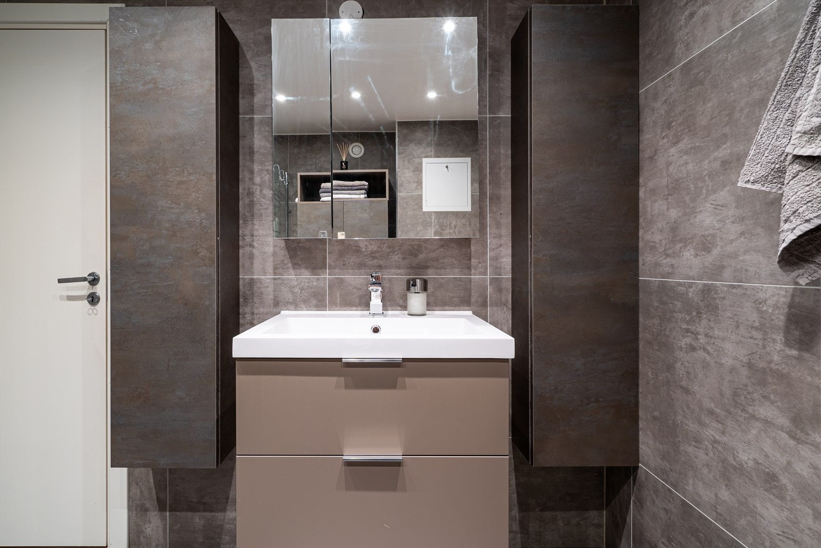Badet er delikat og er holdt i en moderne stil med flislagte overflater, gulvvarme og downlights. Galleribilde