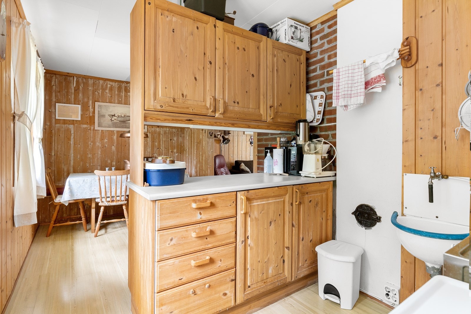 Kjøkkenet har dels åpen løsning mot spisestue. Her har man en enkel heltreinnredning med skuffer og skap. Galleribilde