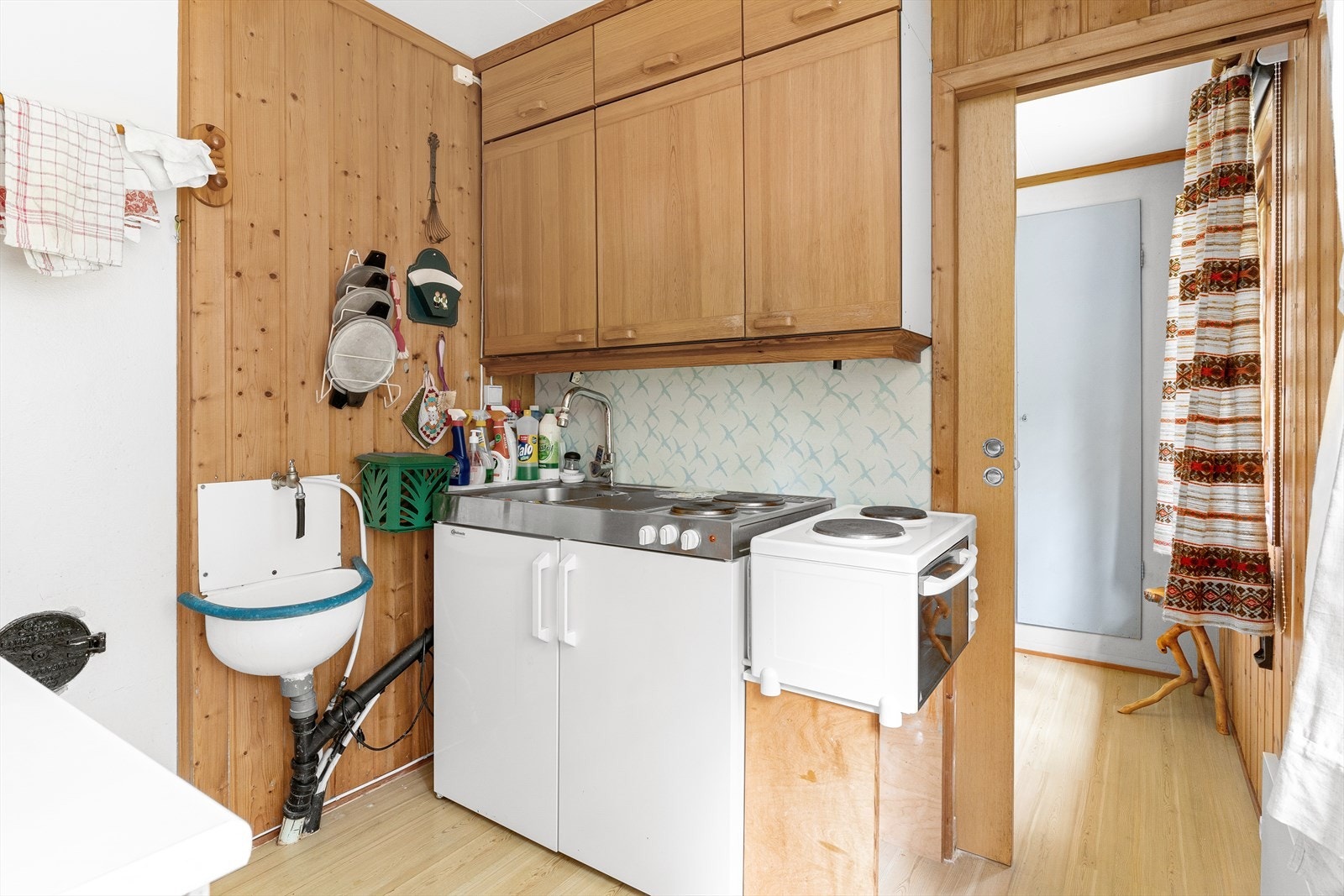 Det er også satt inn en kombinert utslagsvask med kokeplater og kjøleskap under - og på siden av denne kokeplater med en hybelkomfyr under. Galleribilde