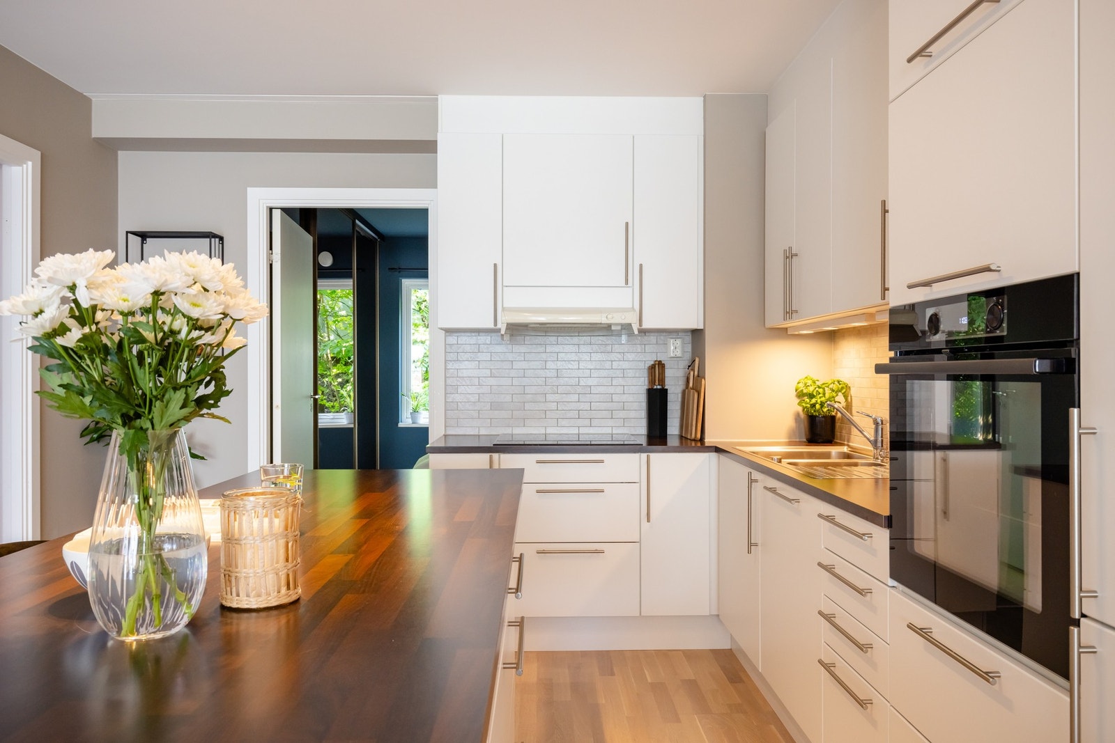 Lys, slett kjøkkeninnredning med laminert benkeplate og nedfelt oppvaskkum med ett-greps armatur. Galleribilde