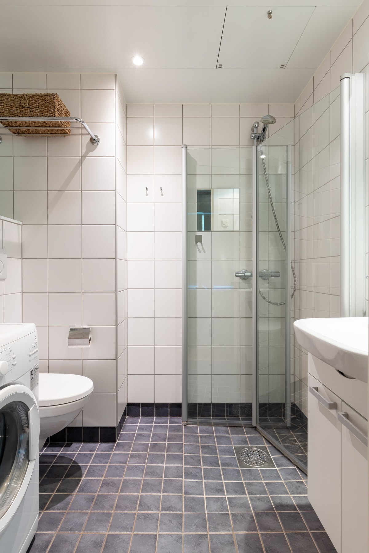 Baderomsinnredningen består av servant med underskap samt speil. Videre er det vegghengt toalett og dusjhjørne med svingbare dusjdører som frigjør plass på gulvet. Galleribilde