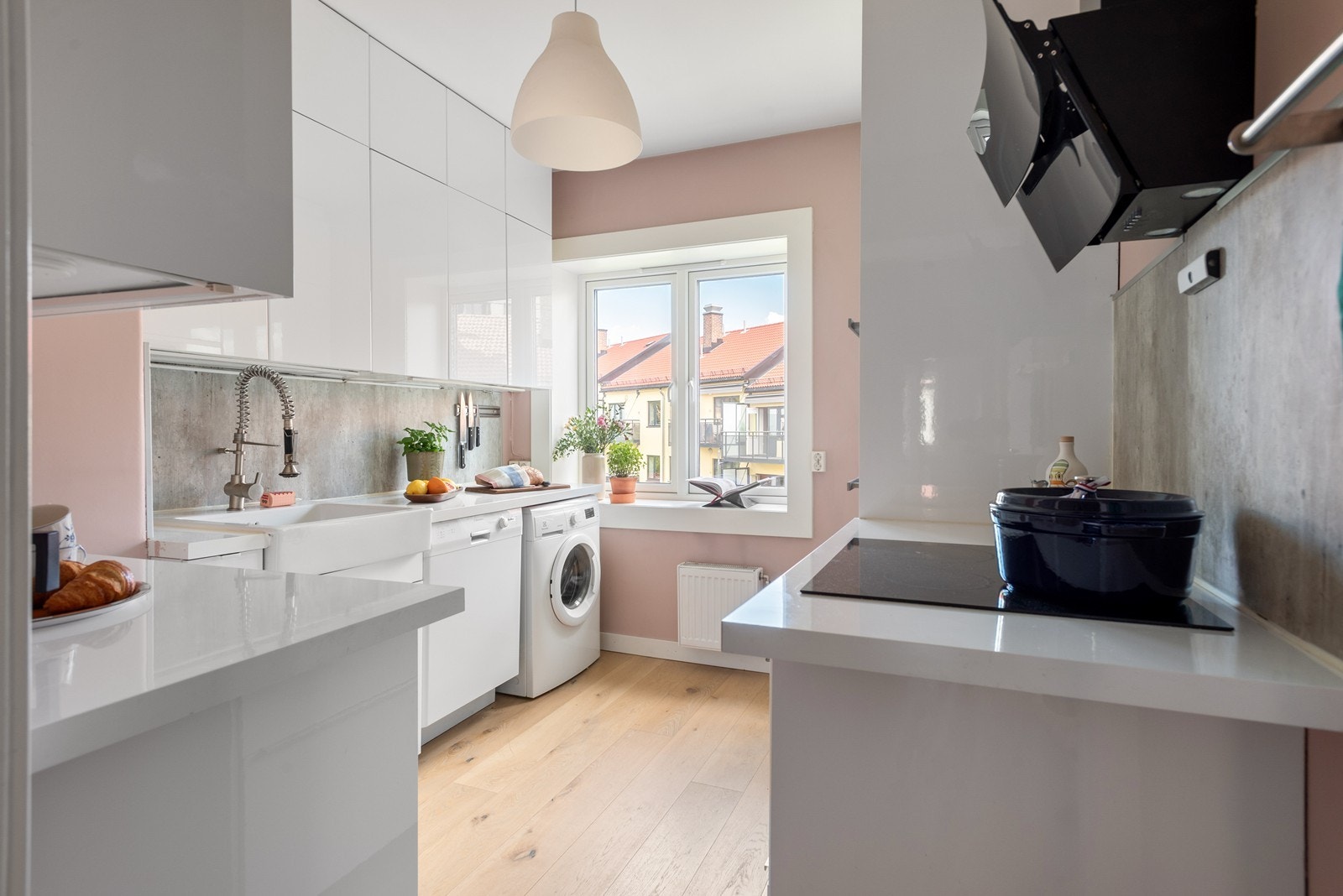 Stilrent kjøkken med mye skapplass og hyggelig utsikt mot bakgård Galleribilde