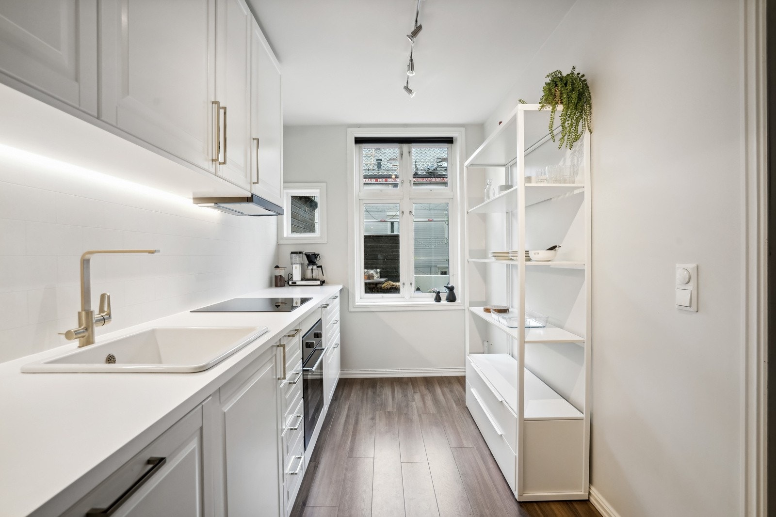 Elegant kjøkkeninnredning med hvite, profilerte fronter. Galleribilde