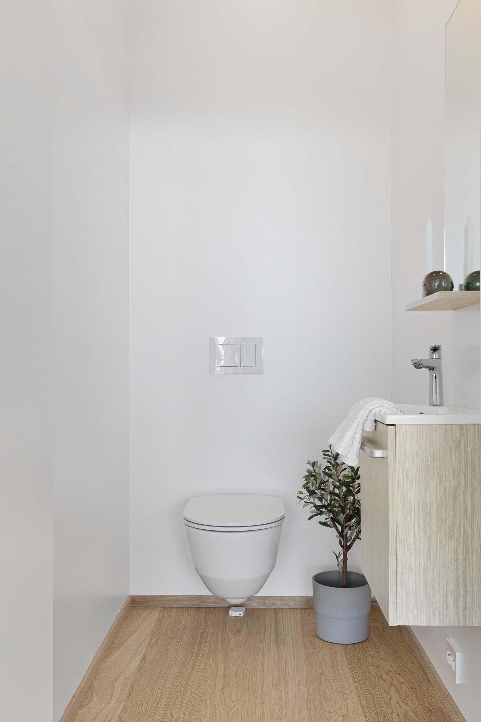 Toalettrommet er innredet med vegghengt toalett og et moderne baderomsmøbel. Møblementet består av heldekkende servant på benkeskap med hvitpigmentert eikefronter og et matchende speil. Galleribilde