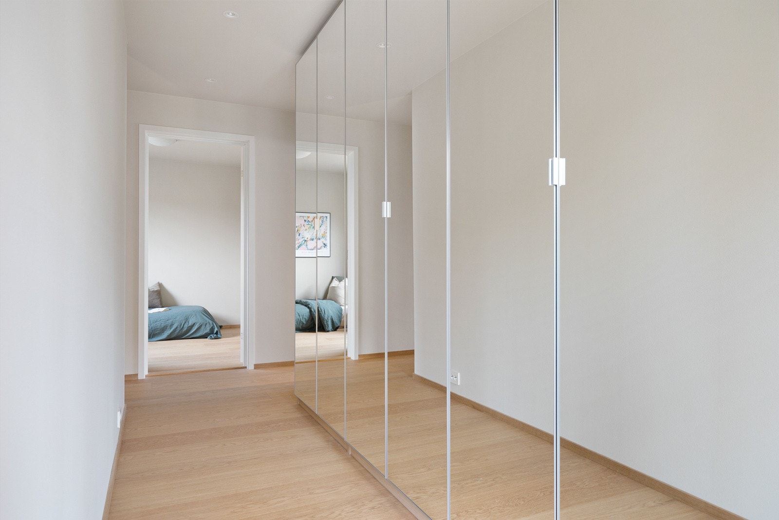 Langs den ene veggen i gangen er det tre doble garderobeskap med speilfronter. Galleribilde