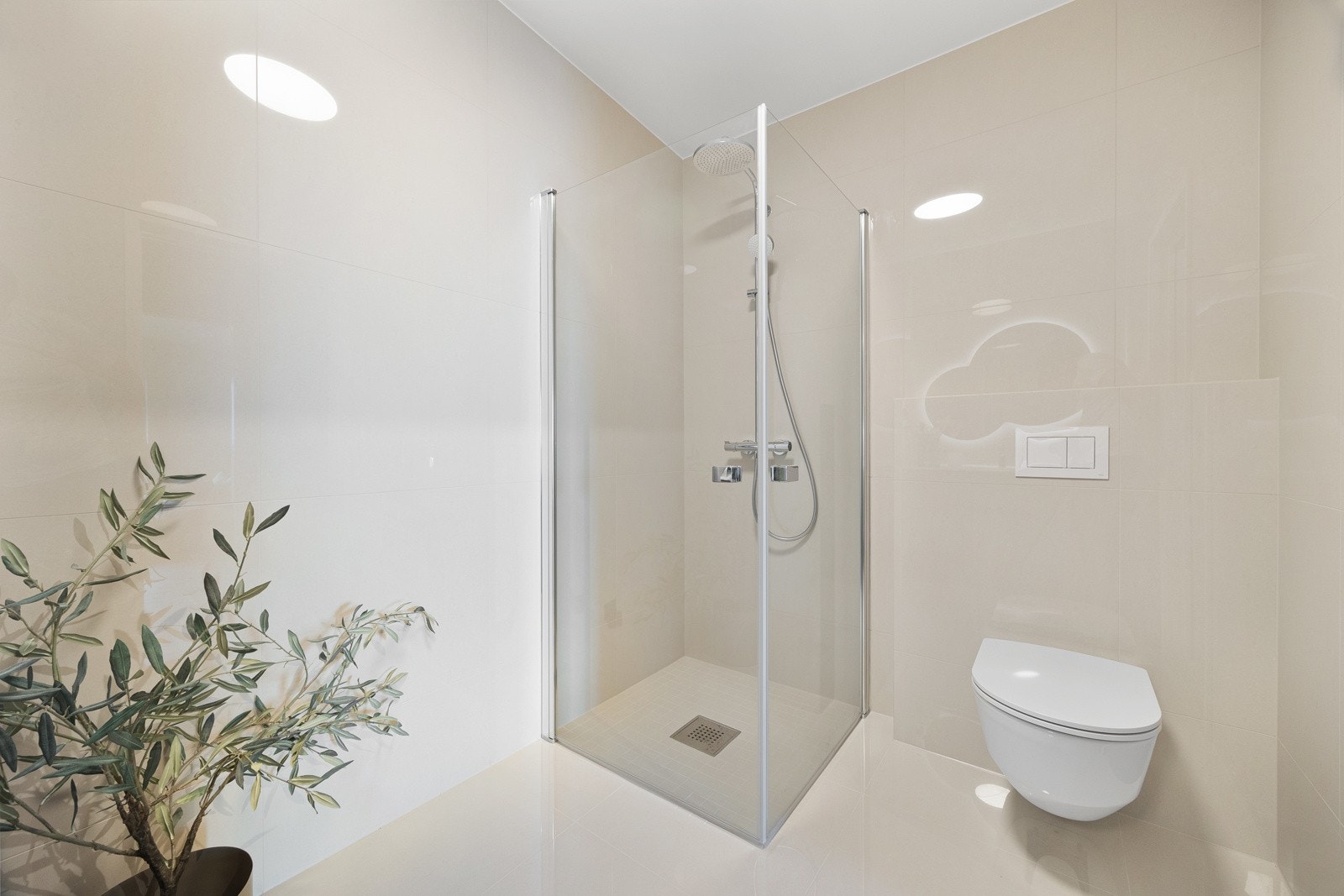 Videre har hvert bad dusjhjørne med regndusj og hånddusj bak rette innfellbare glassdører, samt grå, lekre baderomsinnredninger. Galleribilde