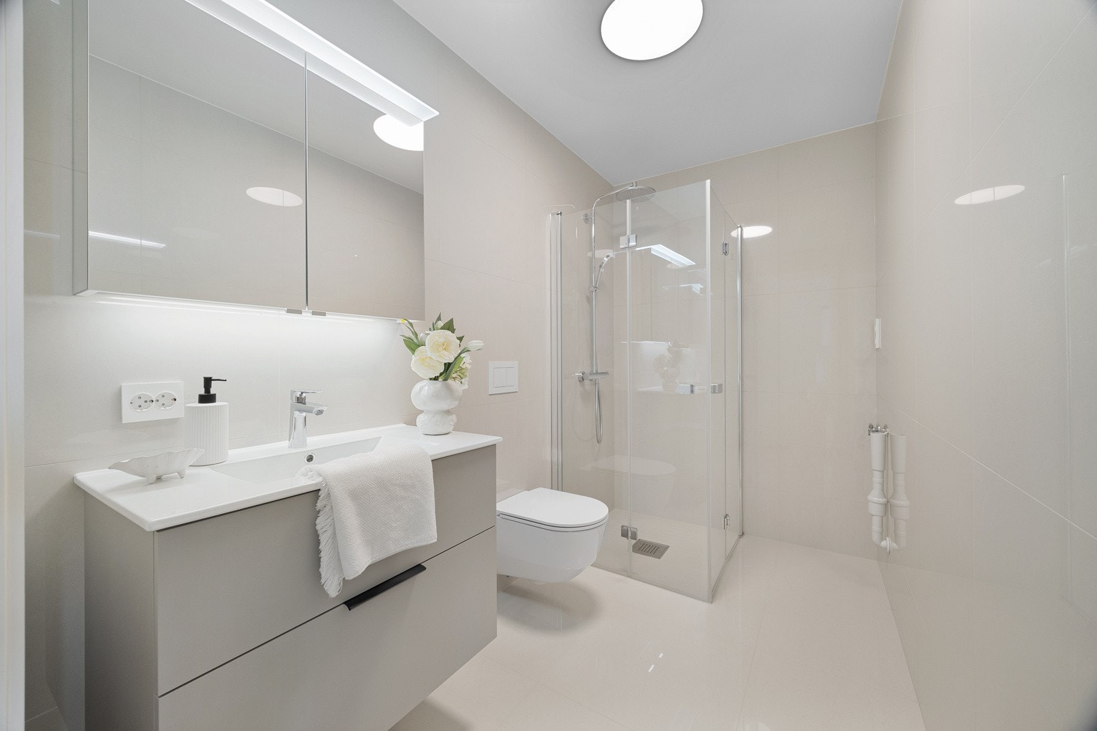 I dusjhjørnet er det rette, innfellbare glassdører og dusjgarnityr med regndusj og hånddusj. Galleribilde