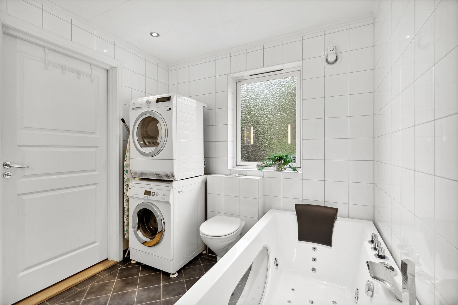 På badet i første etasje er det også et vegghengt toalett samt et deilig badekar med massasjefunksjon og tilhørende armaturer. Galleribilde