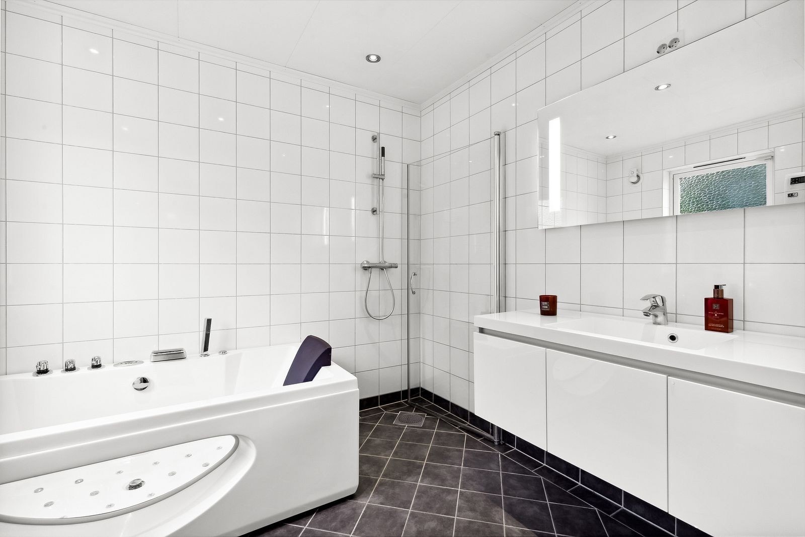 Badet i første etasje er utstyrt med en høyglans baderomsinnredning med underskap og heldekkende servantplate. Galleribilde