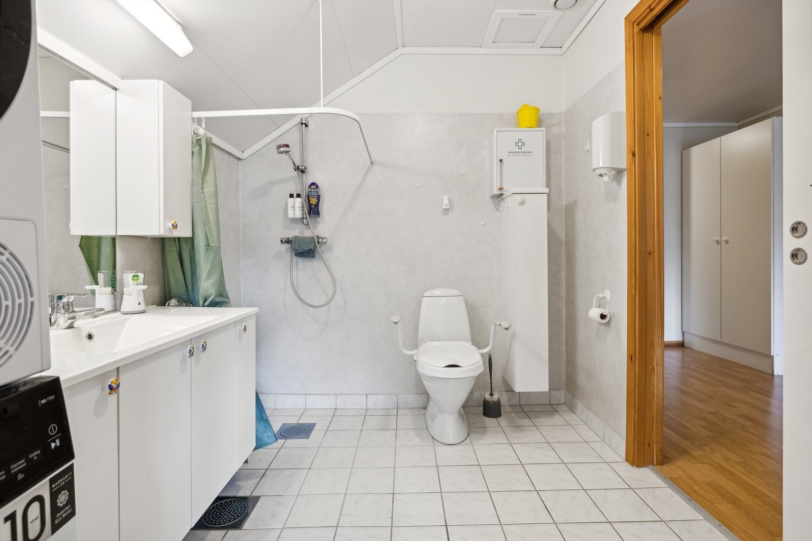 Ellers er badet utstyrt med toalett og dusj, samt servant med gode oppbevaringsmuligheter Galleribilde