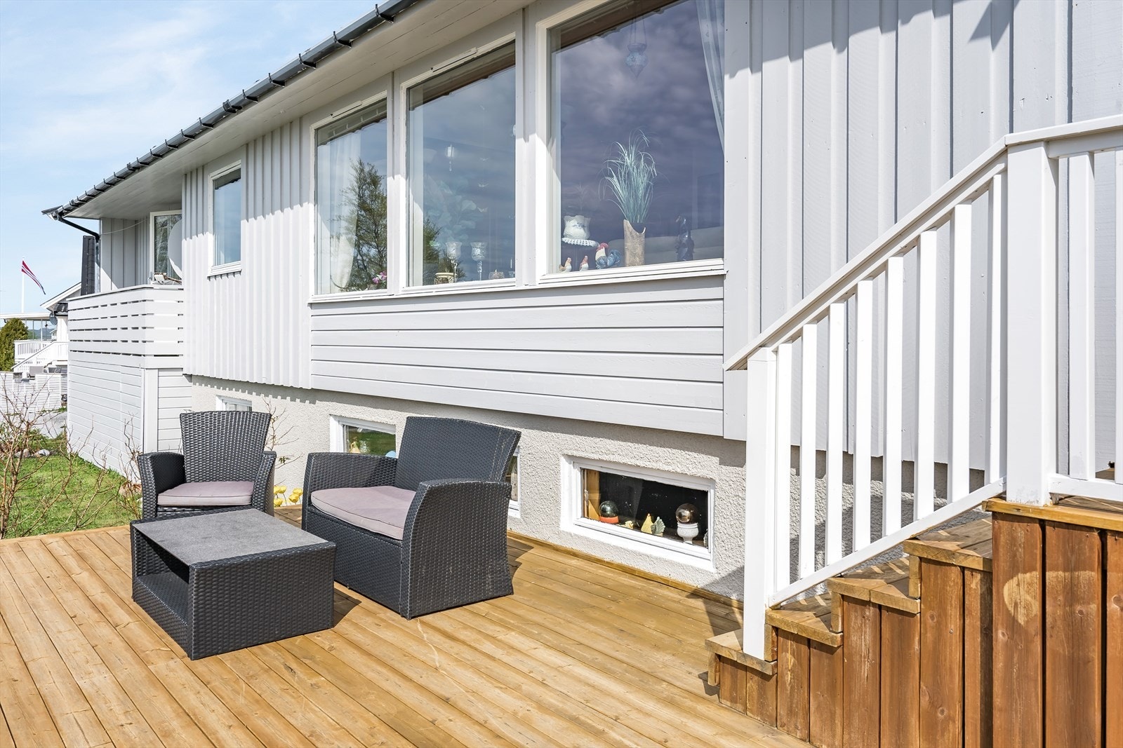 Videre er det nedgang til en sørvestvendt terrasse på ca. 29 m² fra 2021 med gode sol- og utsiktsforhold, samt nedgang til hagen. Skjermet og privat hage med hekk mot veien i vest - her er det plass til lek og moro for de små! Galleribilde