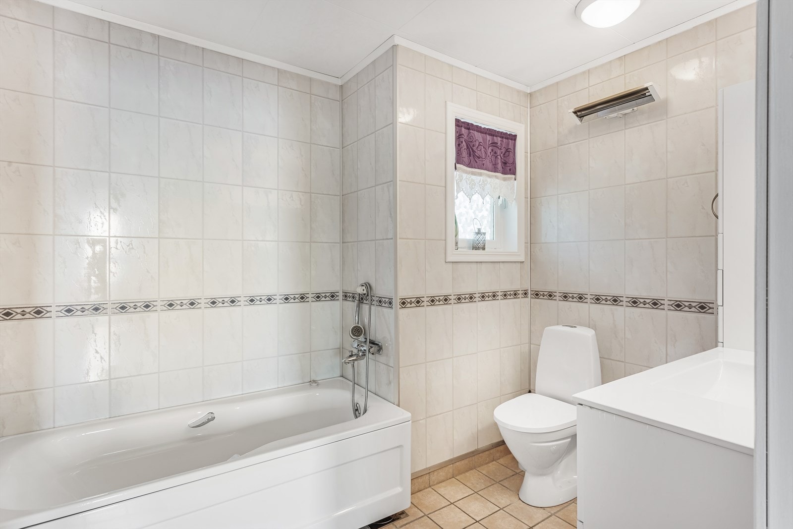 Baderommet er fra byggeår men pusset opp med ny membran og nye fliser på gulvet og nye veggplater i ca. 2002. Det er elektriske varmekabler i gulvet. Galleribilde