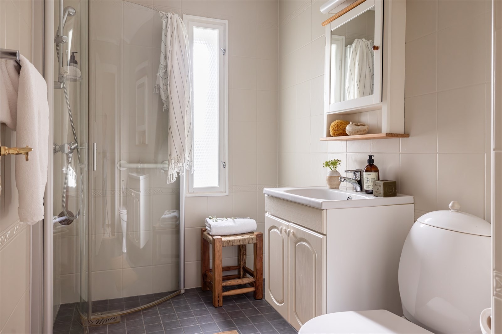 Helfliset bad med varme i gulv. Utstyrt med wc, servantskap, dusjhjørne og innfellbare dusjdører. Galleribilde