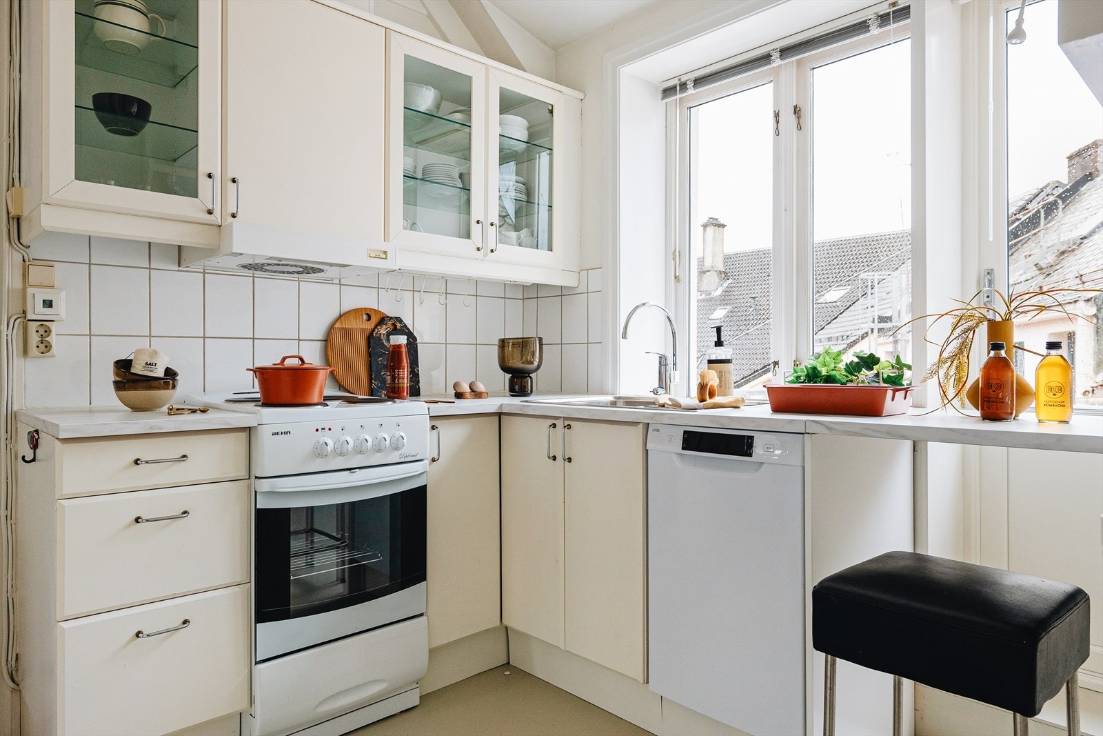 IKEA Kjøkkeninnredning fra 1993-94 med slette fronter, to av overskapene har glassfrotner og laminat benkeplate. Galleribilde