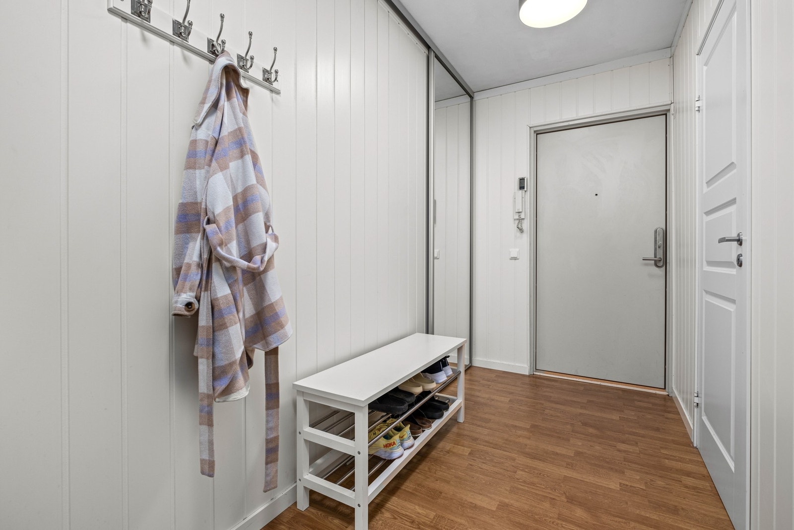 Velkommen inn til en lys og praktisk gang. Her er det montert en skyvedør med speil Galleribilde