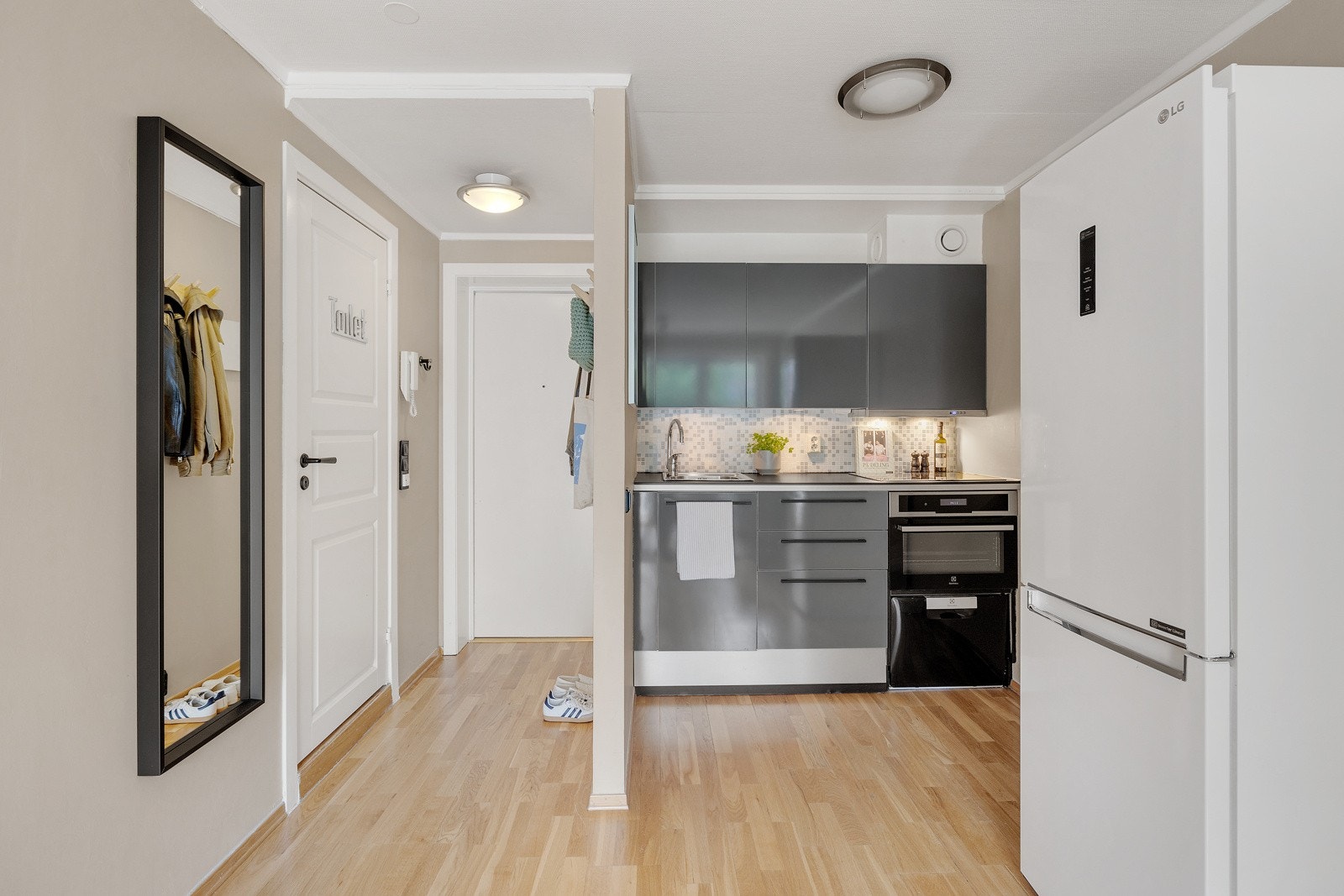 Kjøkkenet har slette høyglans fronter, laminat benkeplate med fliser på bakvegg og enkelte integrerte hvitevarer. Galleribilde