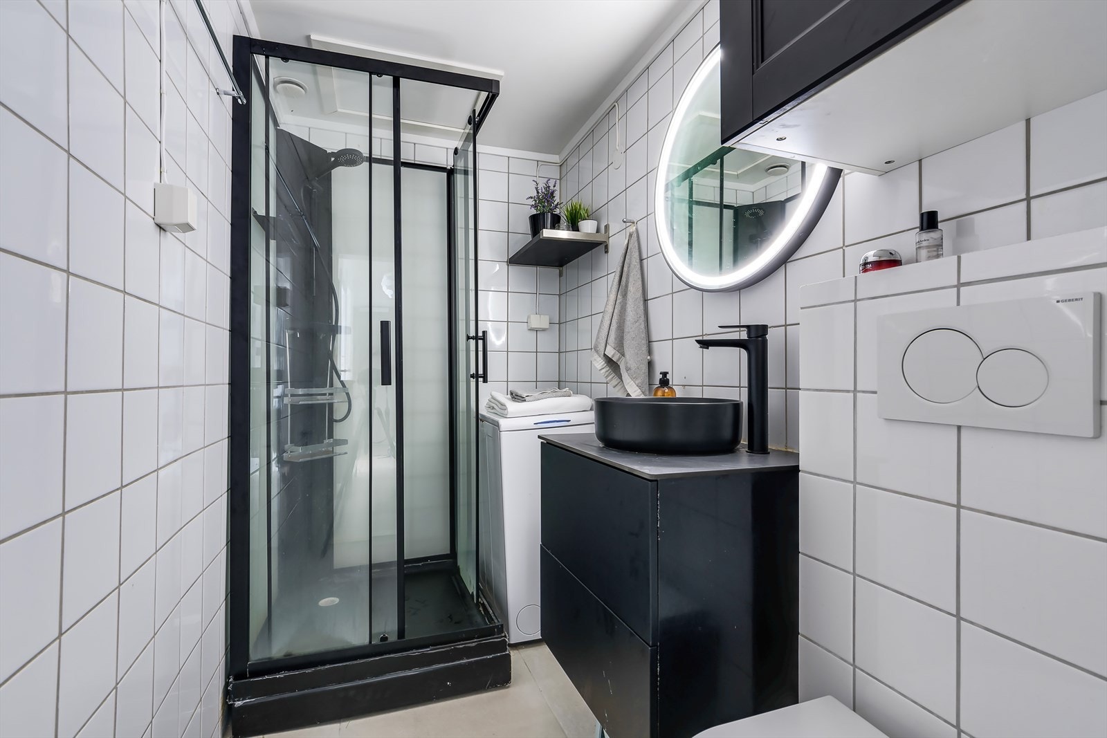 Lyst og pent bad med flislagte overflater, samt varmekabler i gulv Galleribilde