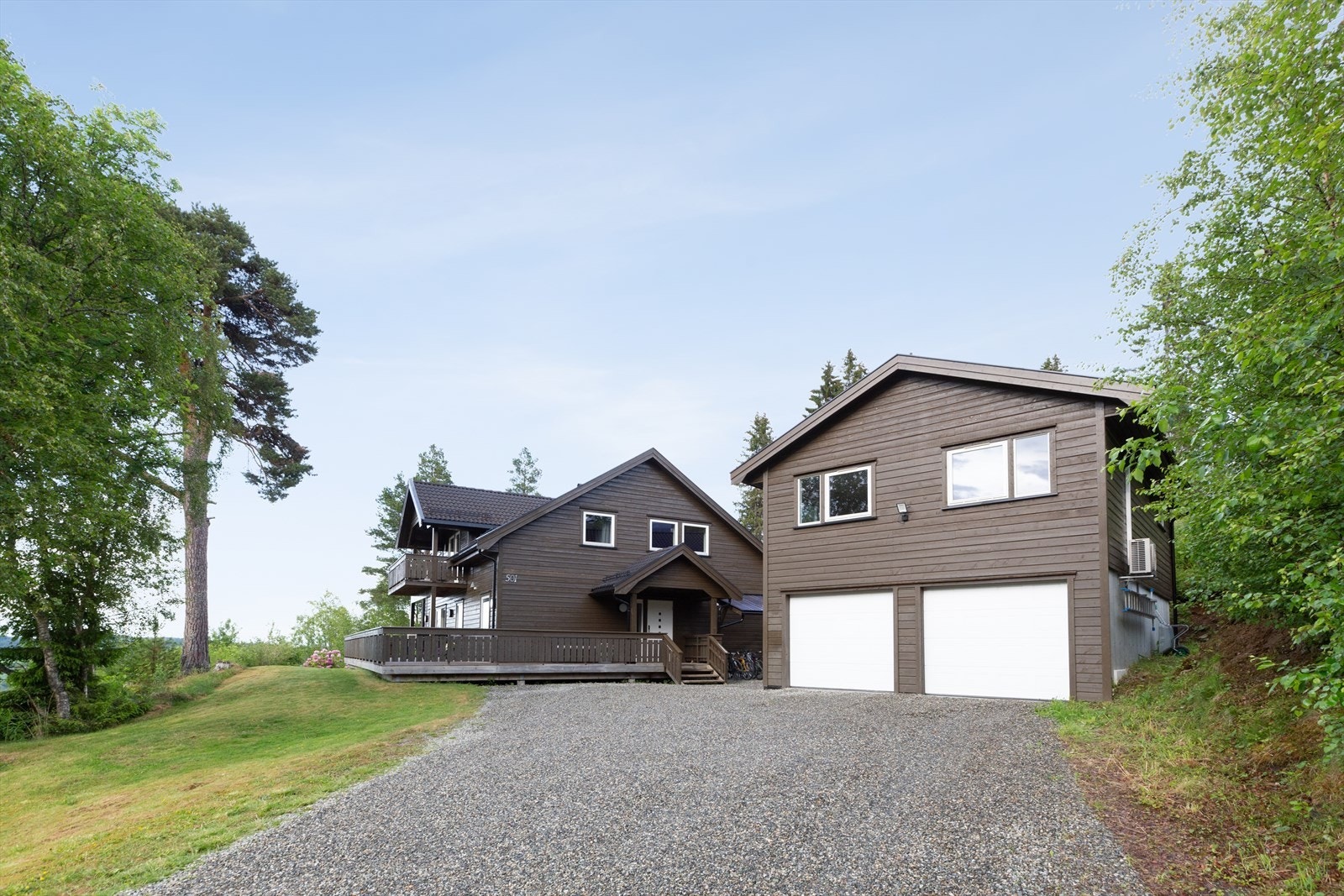 Det er gode parkeringsmuligheter på gruslagt gårdsplass og i stor, frittstående dobbelgarasje med innredet loft. Galleribilde