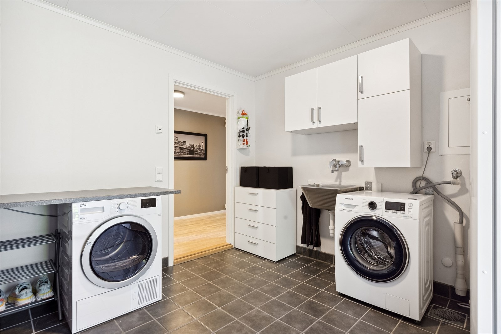 Det praktisk innredede vaskerommet ligger rett ved entreen, vegg- i-vegg med badet. Galleribilde