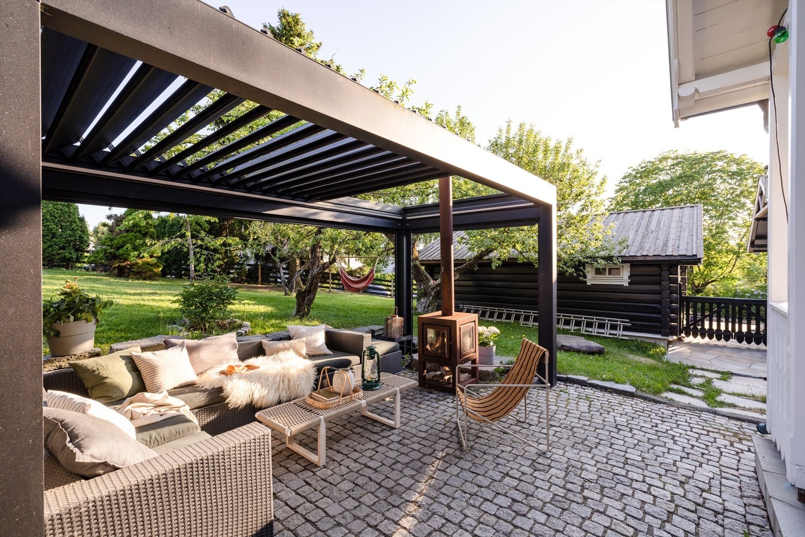 Ved inngangsparti er det etablert en flott pergola med god plass til sofagruppe. Her er det satt inn en peisovn som luner godt på sene sommerkvelder eller på tampen av sesongen Galleribilde