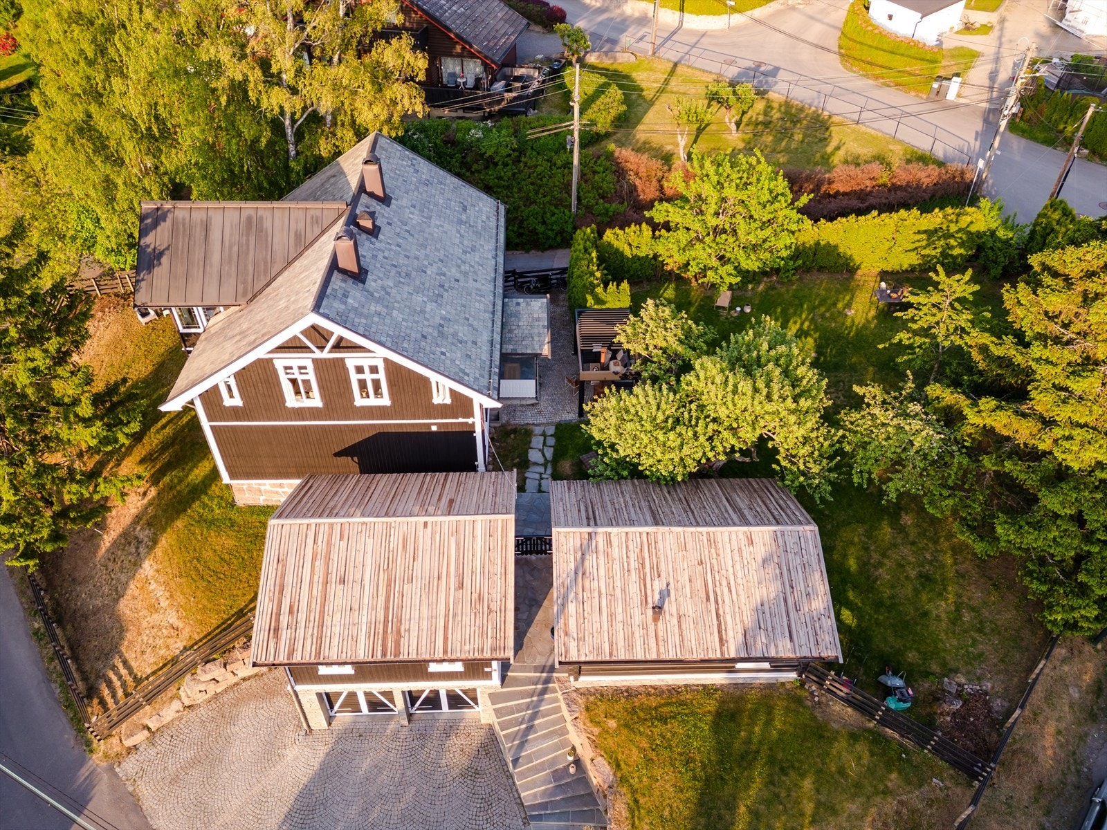 Oversiktsbilde - Eiendommen har i tillegg til dobbelt garasje, plass til ytterligere parkering på den stensatte gårdsplassen Galleribilde