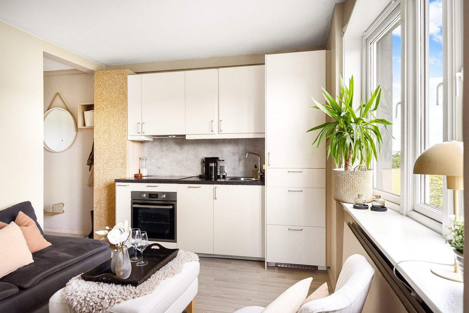 Lys kjøkkeninnredning bestående av glatt laminert kjøkkeninnredning som er malt, laminert benkeplate, kum med ettgreps blandebatteri, kullfiltervifte over integrert koketopp/ovn, integrert
kjøleskap og integrert oppvaskmaskin. Galleribilde