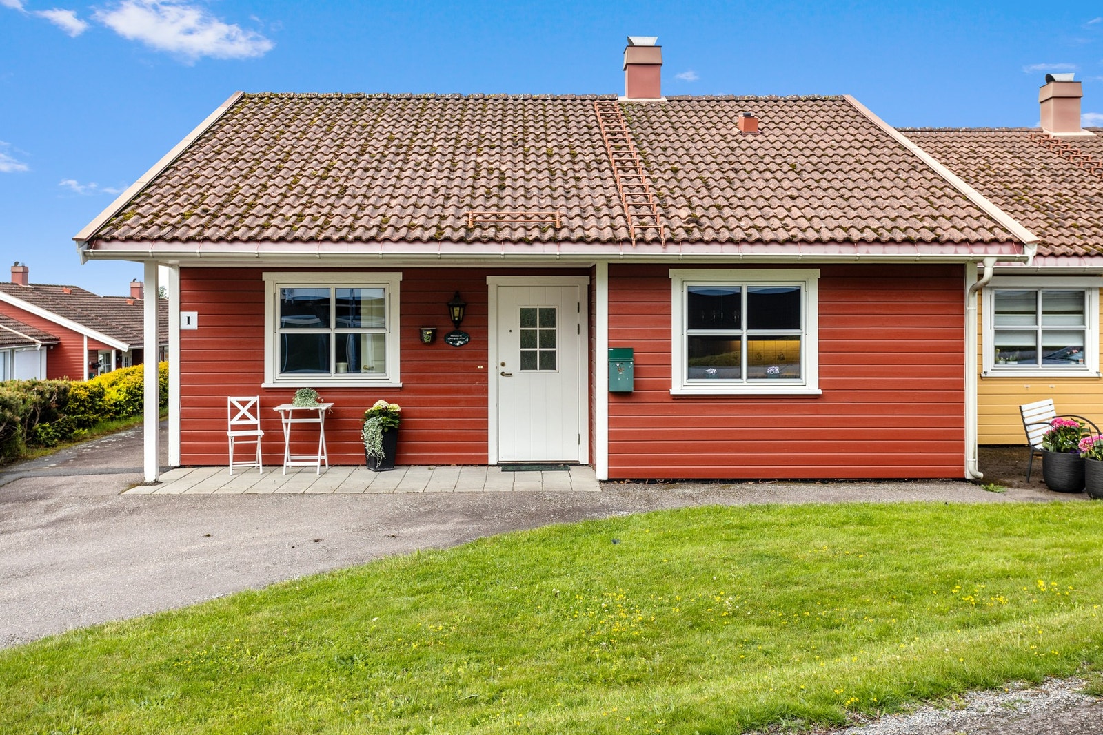 På østsiden, i tilknytning hjemmets overbygde inngangsparti, er det også et hellelagt parti på ca. 8 m² med plass til utemøbler. Galleribilde