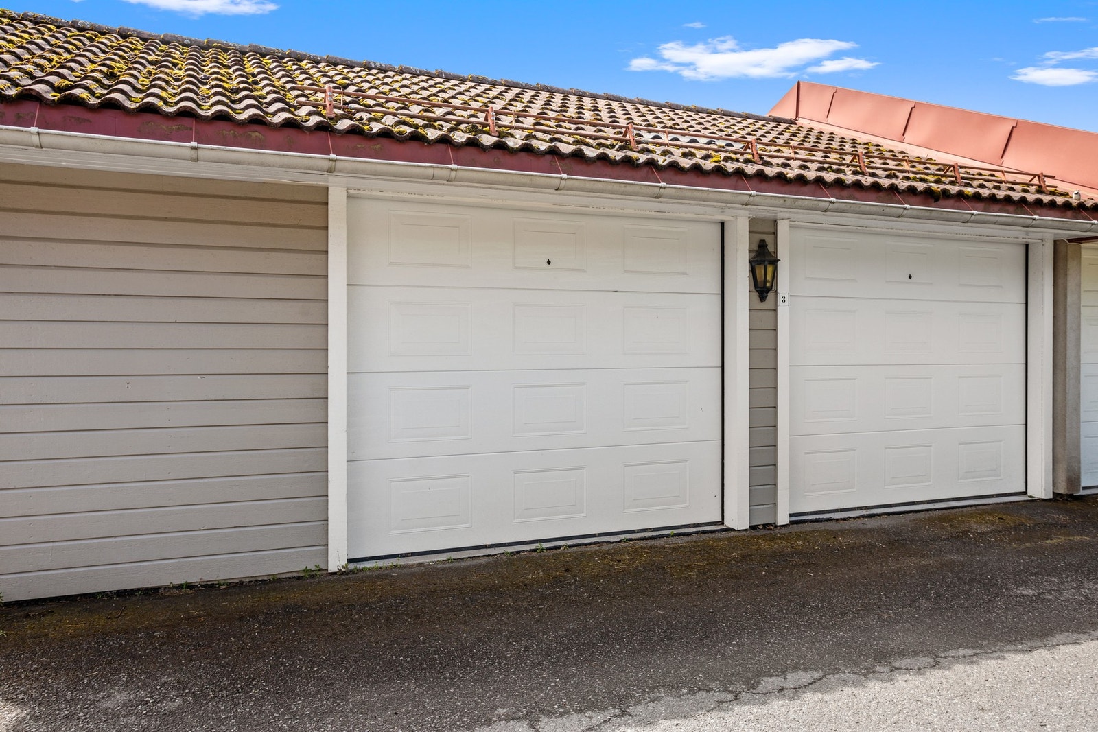Garasjen har nyere leddport i hvitlakkert med motor-/fjernstyrt styring. Galleribilde