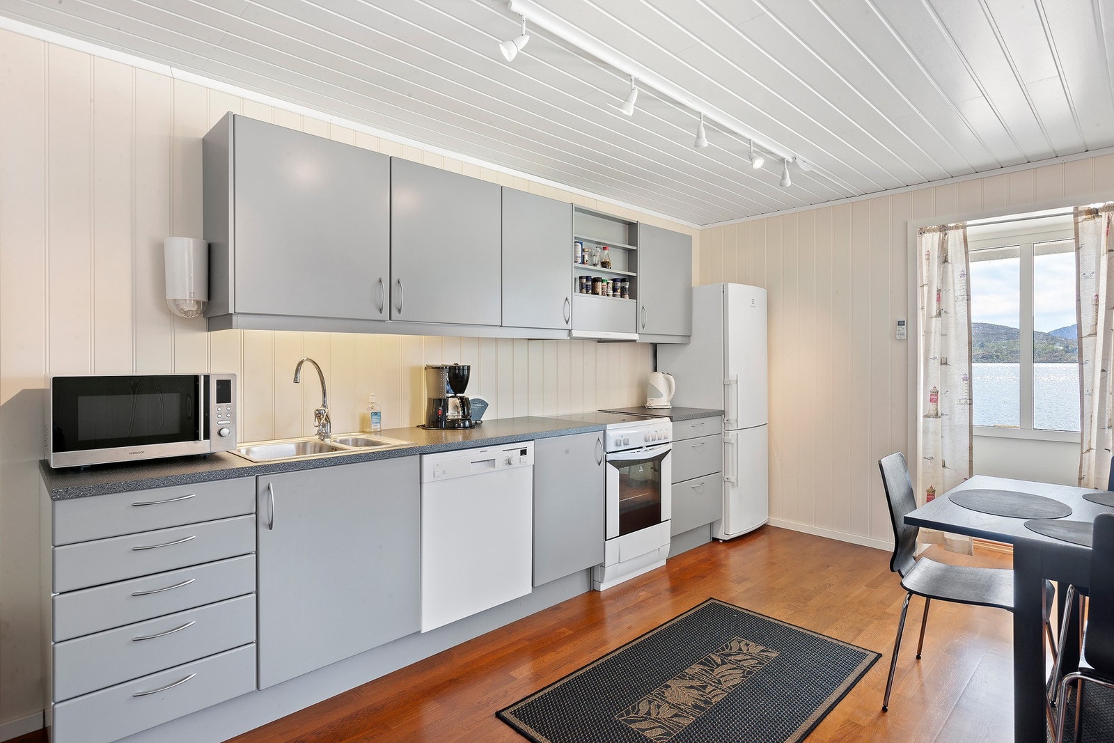 Kjøkkenet har glatte fronter og benkeplate av laminat. Det er kjøkkenventilator med avtrekk ut. Galleribilde