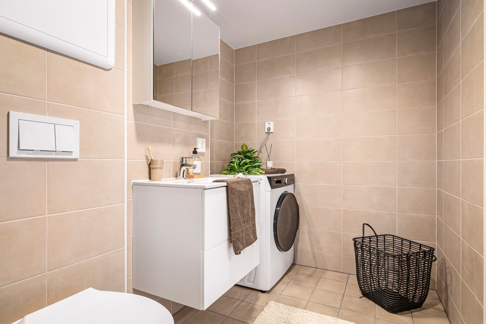 Delikate fliser, flott og tidløs innredning og opplegg for vaskemaskin Galleribilde