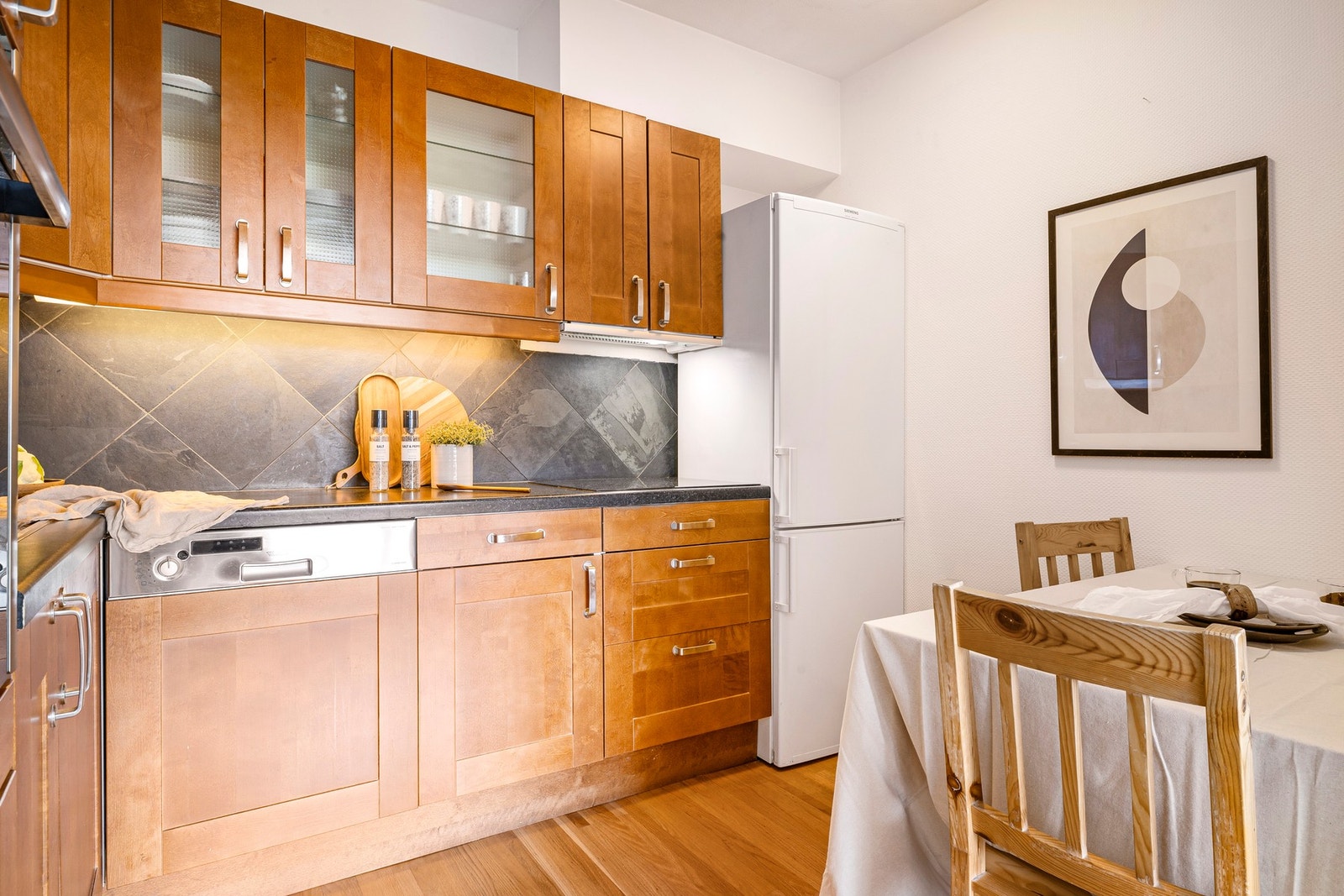 Det er fliser mellom benkeplate og overskap Galleribilde