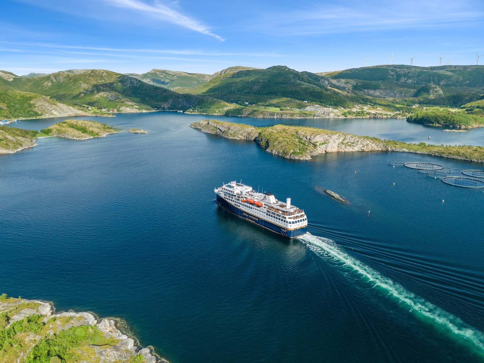 Fra tomtene kan man se Hurtigruten passere. Galleribilde