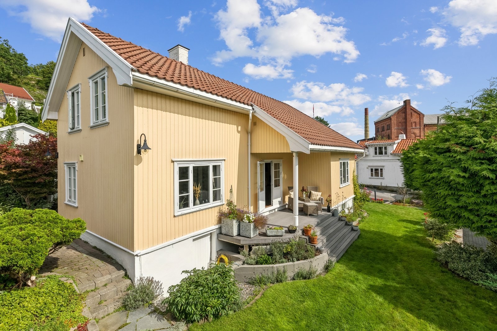 Denne eiendommen tar seg ut fra mange kanter. Her ser du utgangen fra stua. Sett deg med kaffekoppen her og betrakt din egen hage Galleribilde