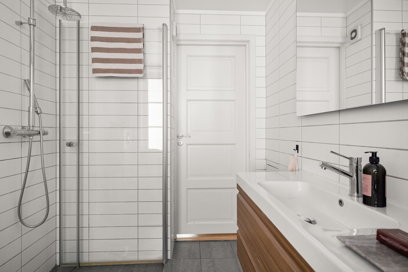 Flislagt bad med gulvvarme og nedsenket himling med downlights. Galleribilde