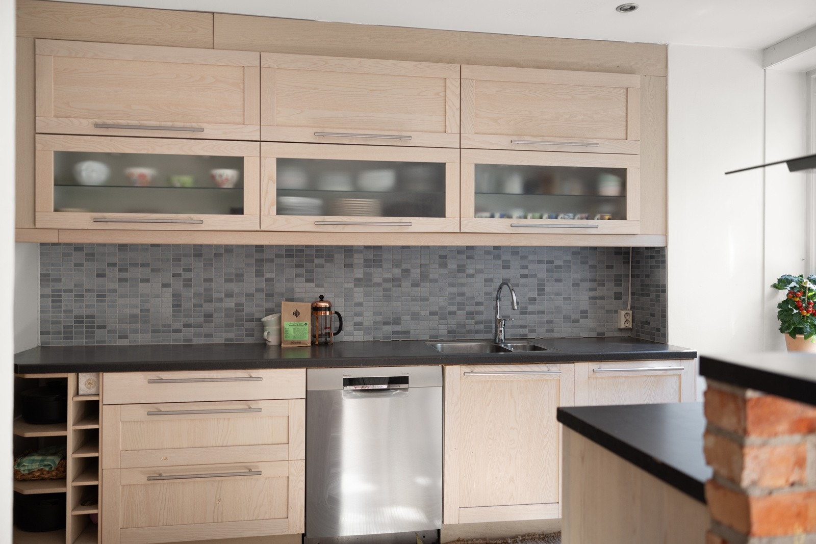 Kjøkkeninnredningen har lyse, profilerte fronter og fliser over benkeplate. Galleribilde