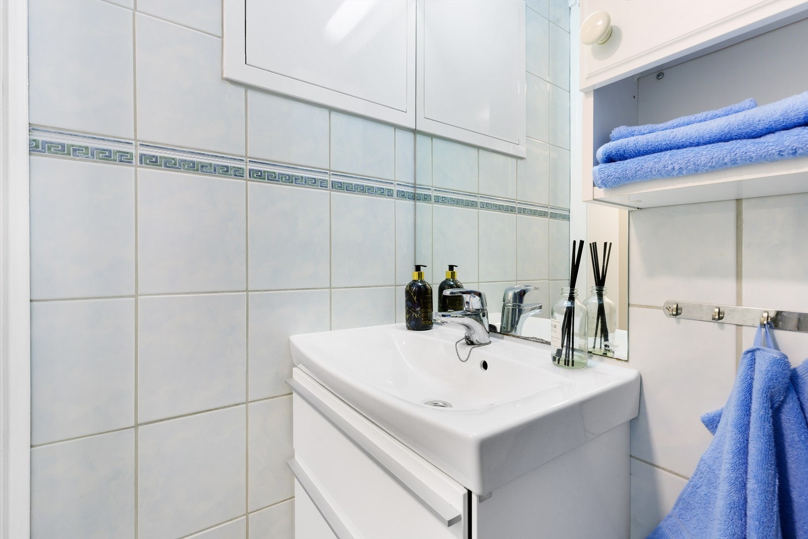 Baderom med lyse fliser. Her er det byttet vaske m/skuffer, wc og blandebatteri i dusj i seinere tid. Galleribilde