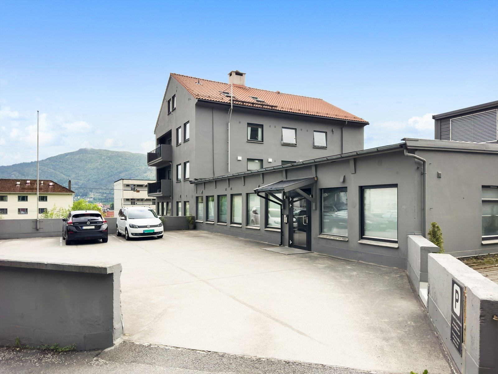 Oppgraderte fasader fra 2021, beliggende i naturskjønt område med utsikt til fjellene. Gjesteparkering til bygget. Galleribilde