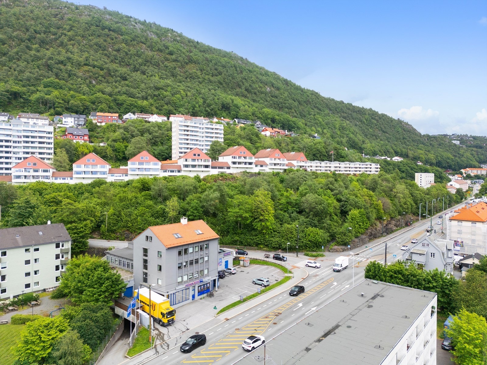 Moderne boligkomplekser omgitt av frodig natur og fjell, nær sentrale transportveier og byfasiliteter. Galleribilde