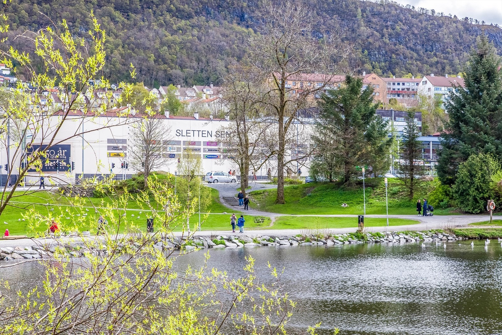 Sjarmerende boligområde med park og vann, nær Sletten senter og gode transportforbindelser. Naturskjønn og praktisk beliggenhet. Galleribilde