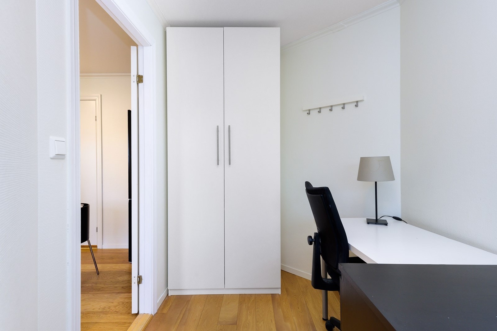 Lyst og innbydende kontorrom med praktisk oppbevaringsløsning og moderne arbeidsplass. Galleribilde