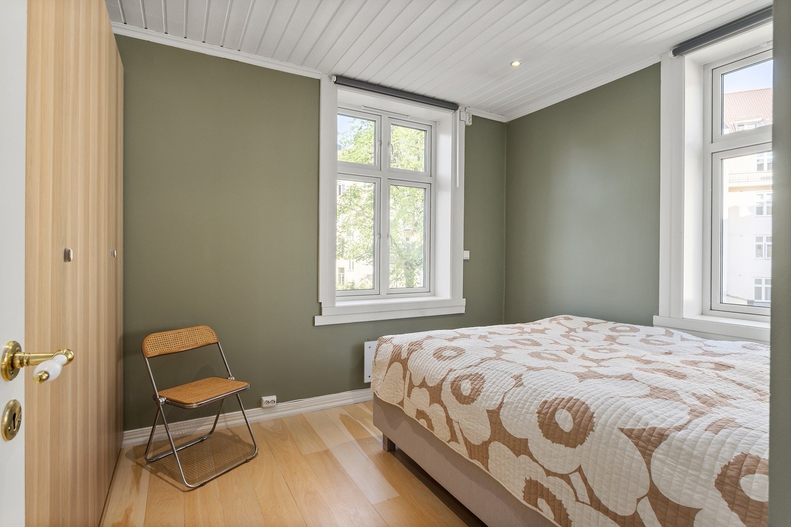 Det romslige soverommet har store vinduer som gir mye naturlig lys fra flere vinkler Galleribilde