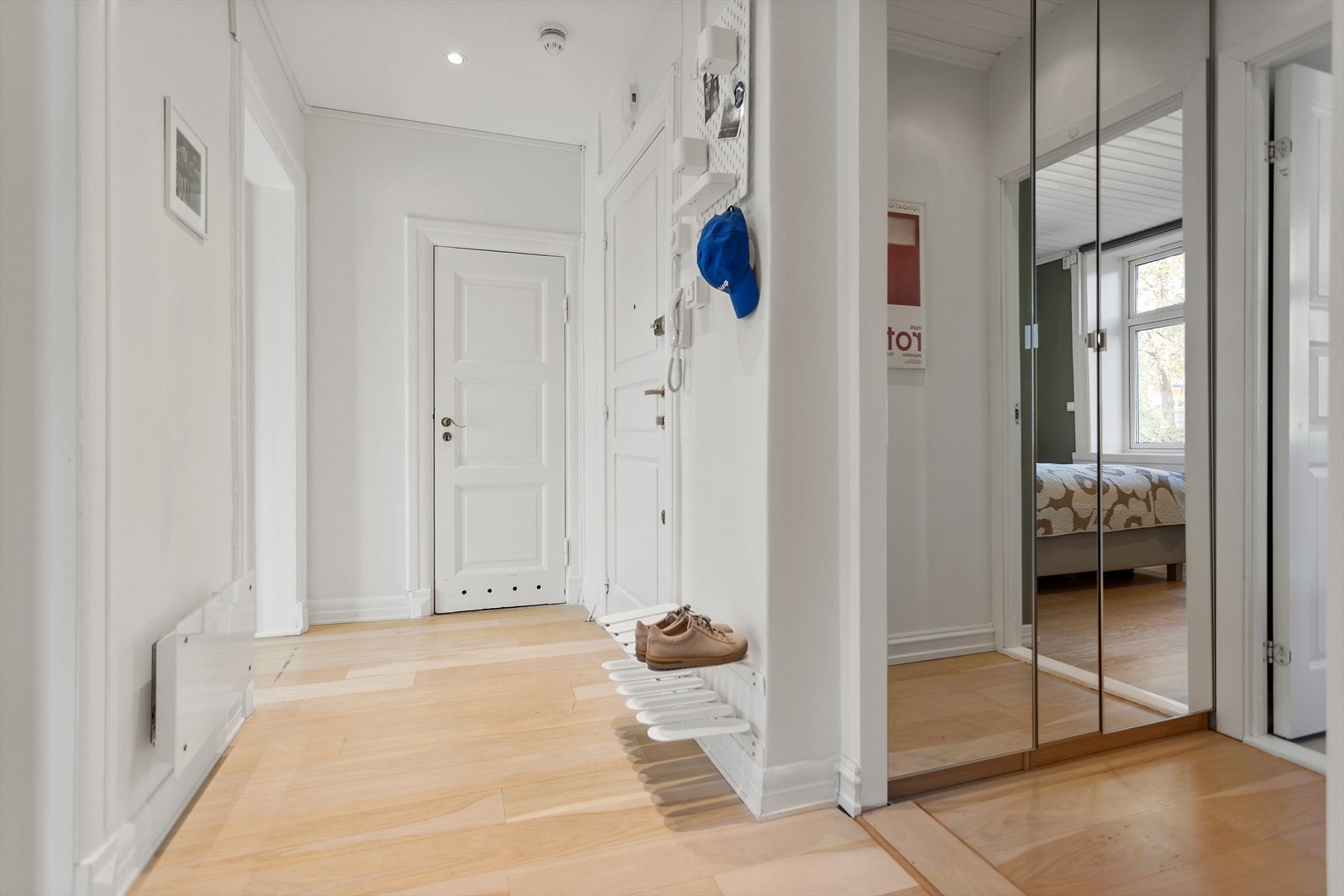 Innbydende entré som gir et godt førsteinntrykk av boligen. Her er det god plass til oppheng av jakker og sko i garderobeskap. Speilskap med ytterligere oppbevaring. Galleribilde