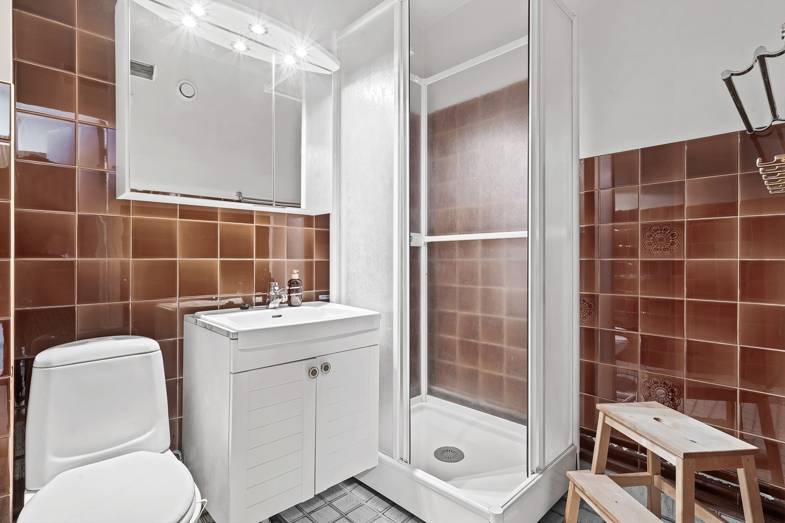 - Baderom med malt betong og fliser på vegger, og fliser på gulv. Badet er innredet med klosett, servant nedfelt i innredning, speilskap og dusjkabinett - Galleribilde