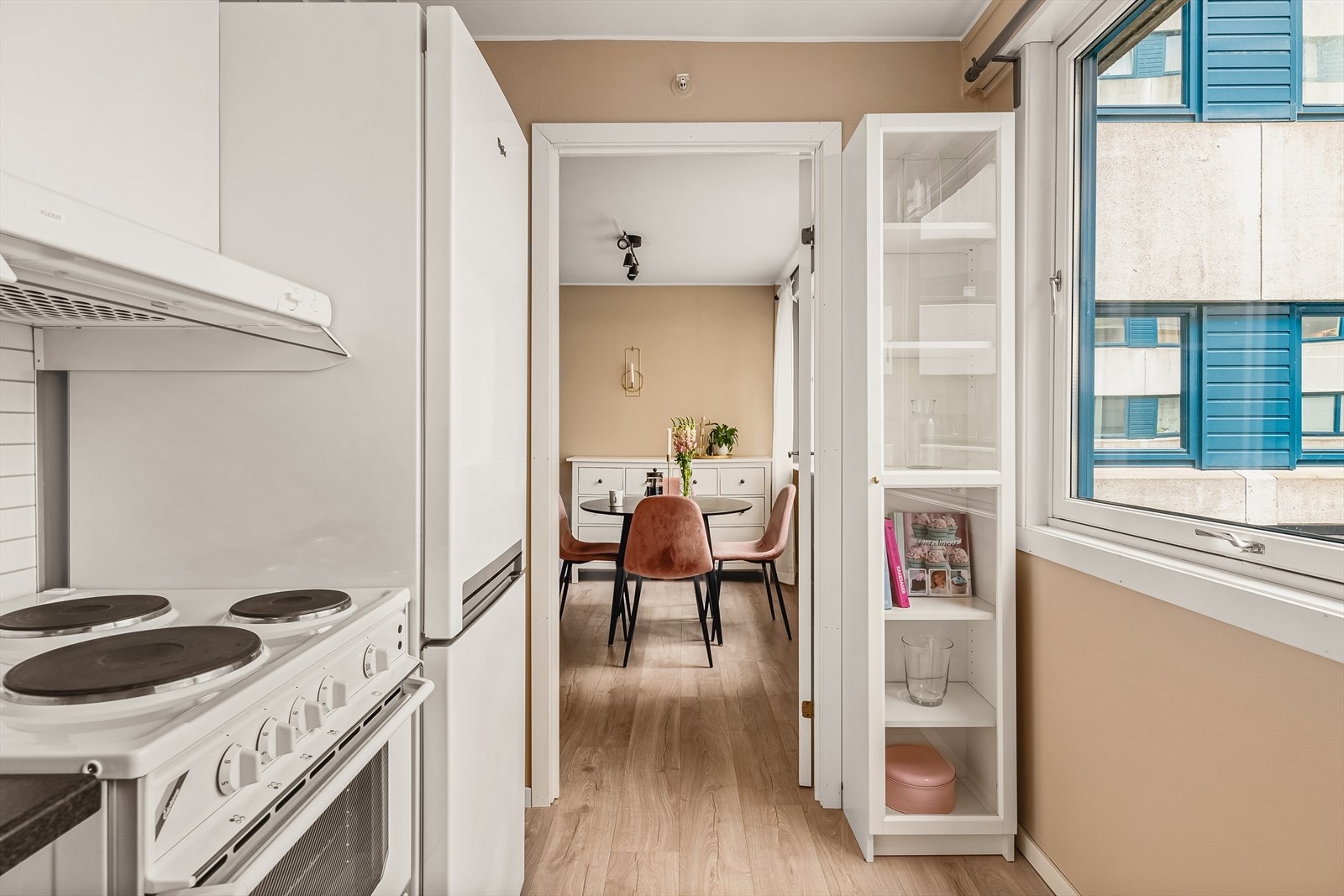 Kjøkkeninnredningen har slette hvite fronter, laminat benkeplate, stål vaskekum, ventilator og opplegg for oppvaskmaskin. Galleribilde