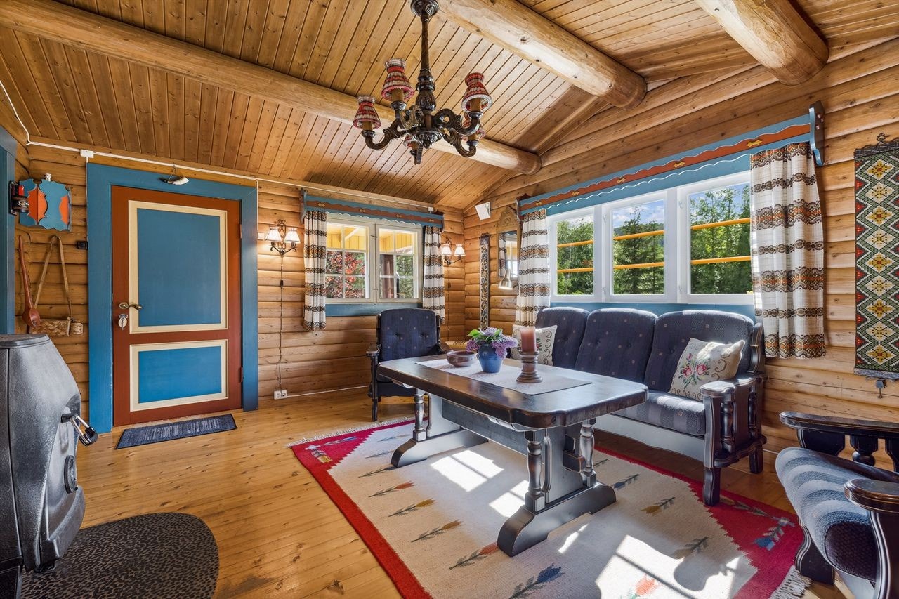 Stuen har tømmervegger og skråhimling med tømmerdragere Galleribilde