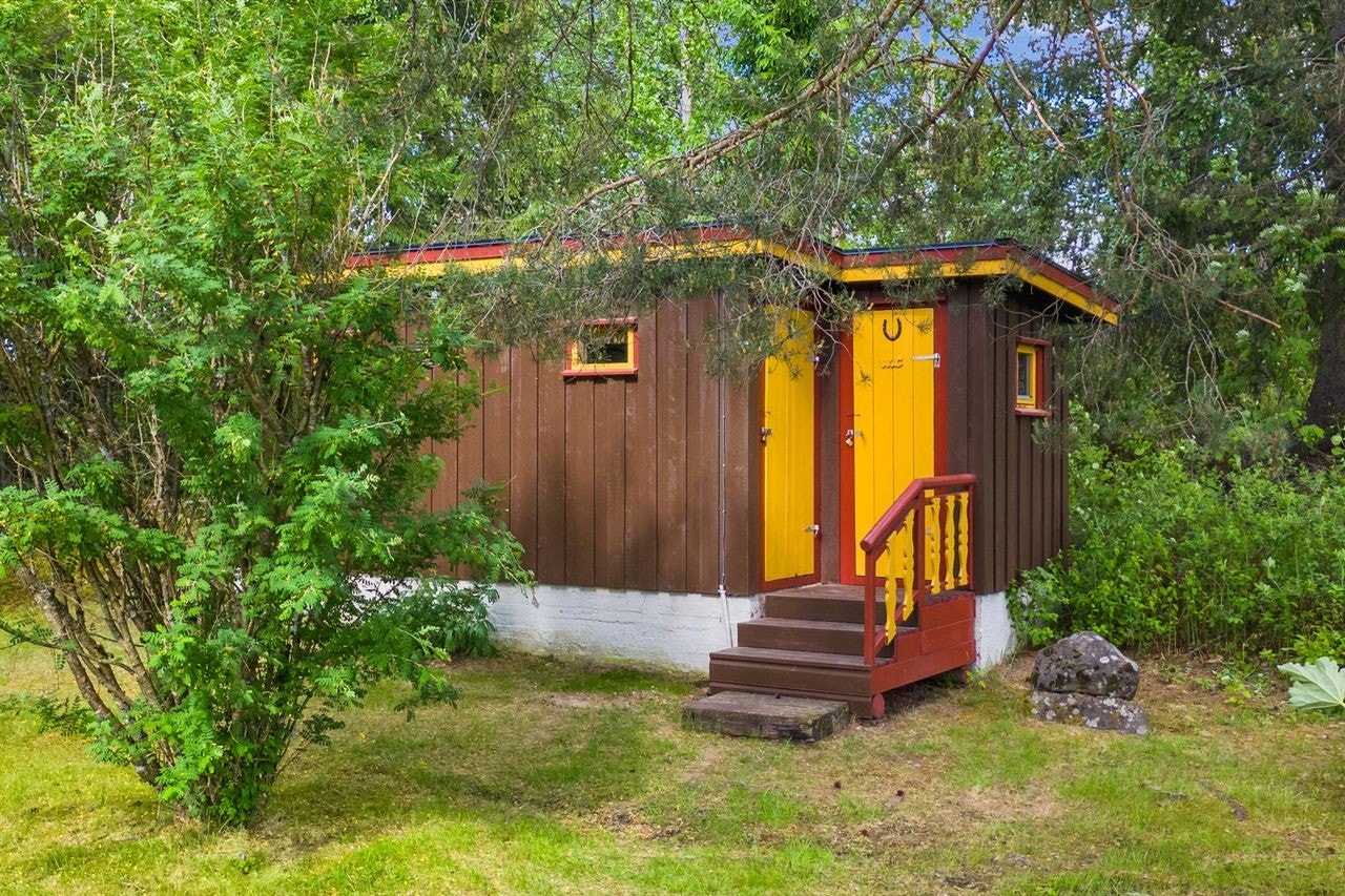 Uthus som inneholder utedo og to boder Galleribilde